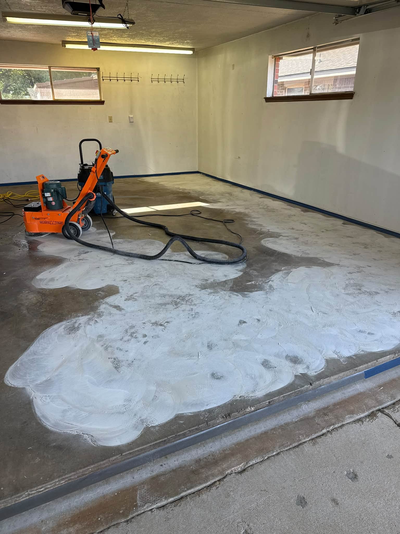 Diamond grinder and dust extractor on the garage slab