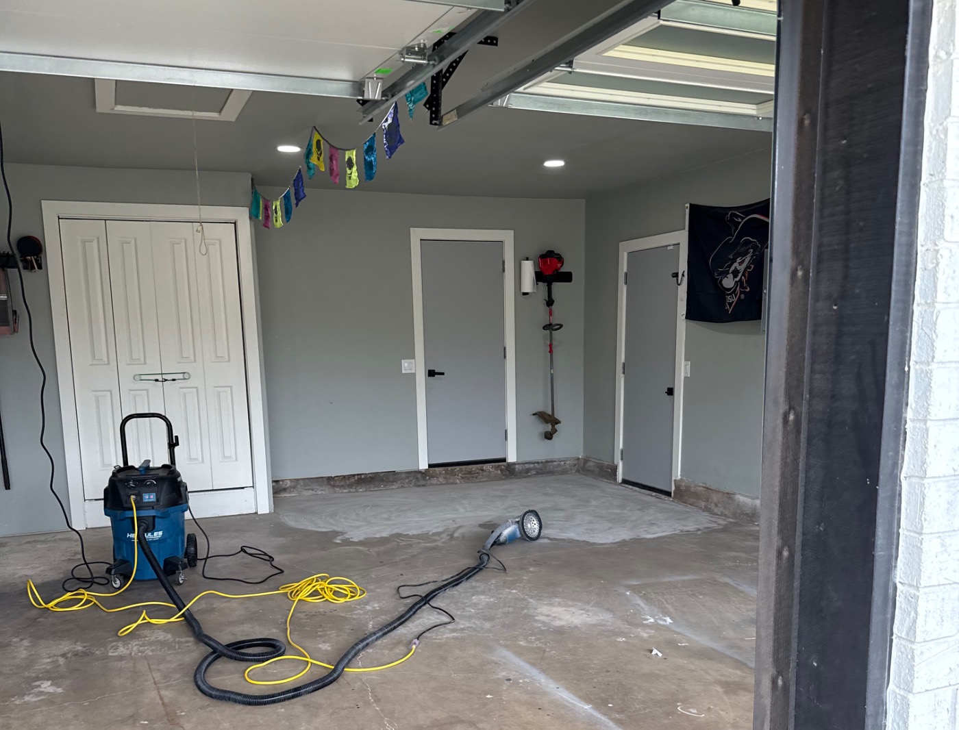 Stained and cracked two-car garage concrete floor before coating